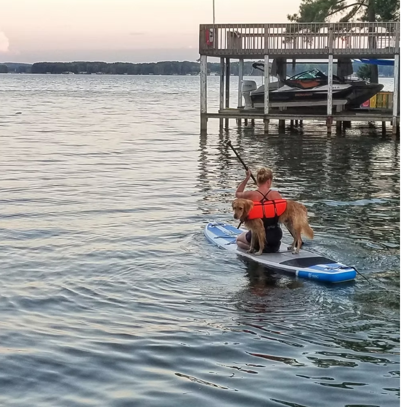 Amy on paddleboard with dog Buddy